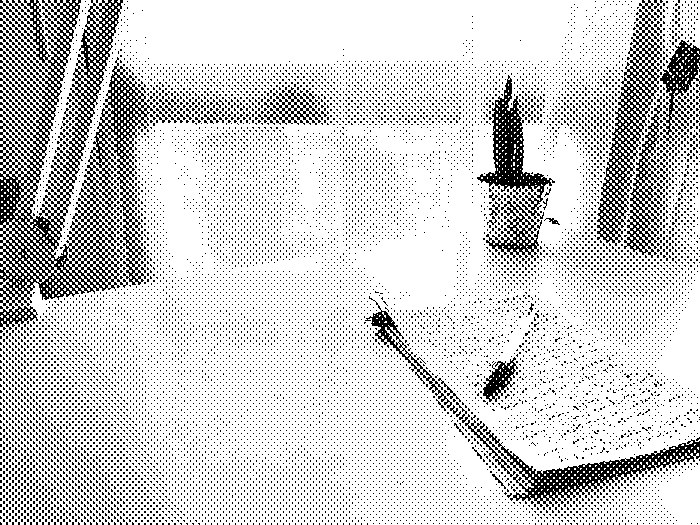 “A Bic pen lying on stack of scrap paper on which a few lines of text is handwritten”