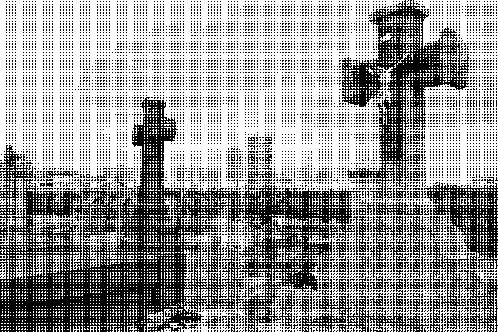 Distant view of a city’s skyscrapers taken from a cemetery, with a few graves and tombstones in the foreground